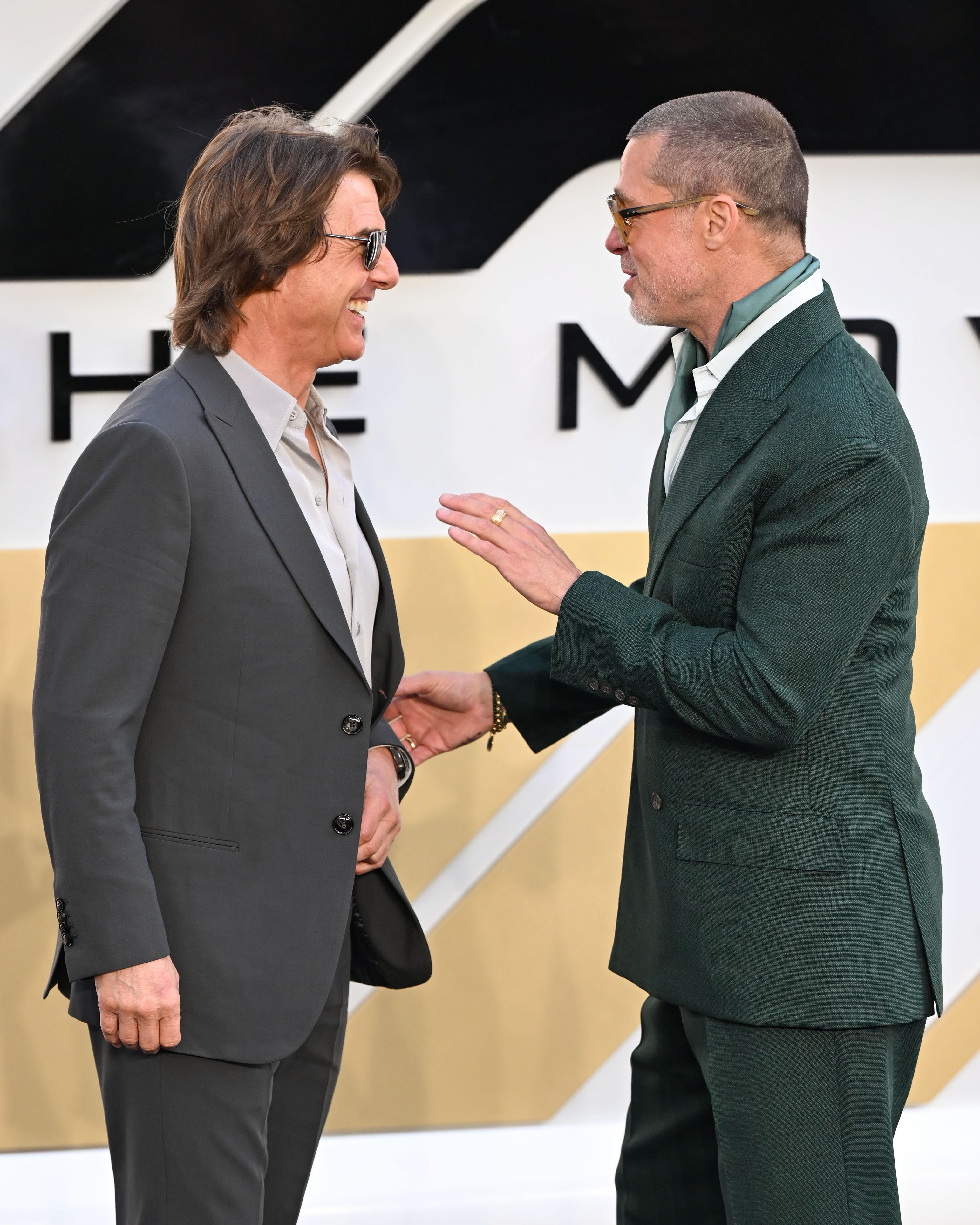 Brad Pitt and Tom Cruise converse at the 'F1' premiere in London.