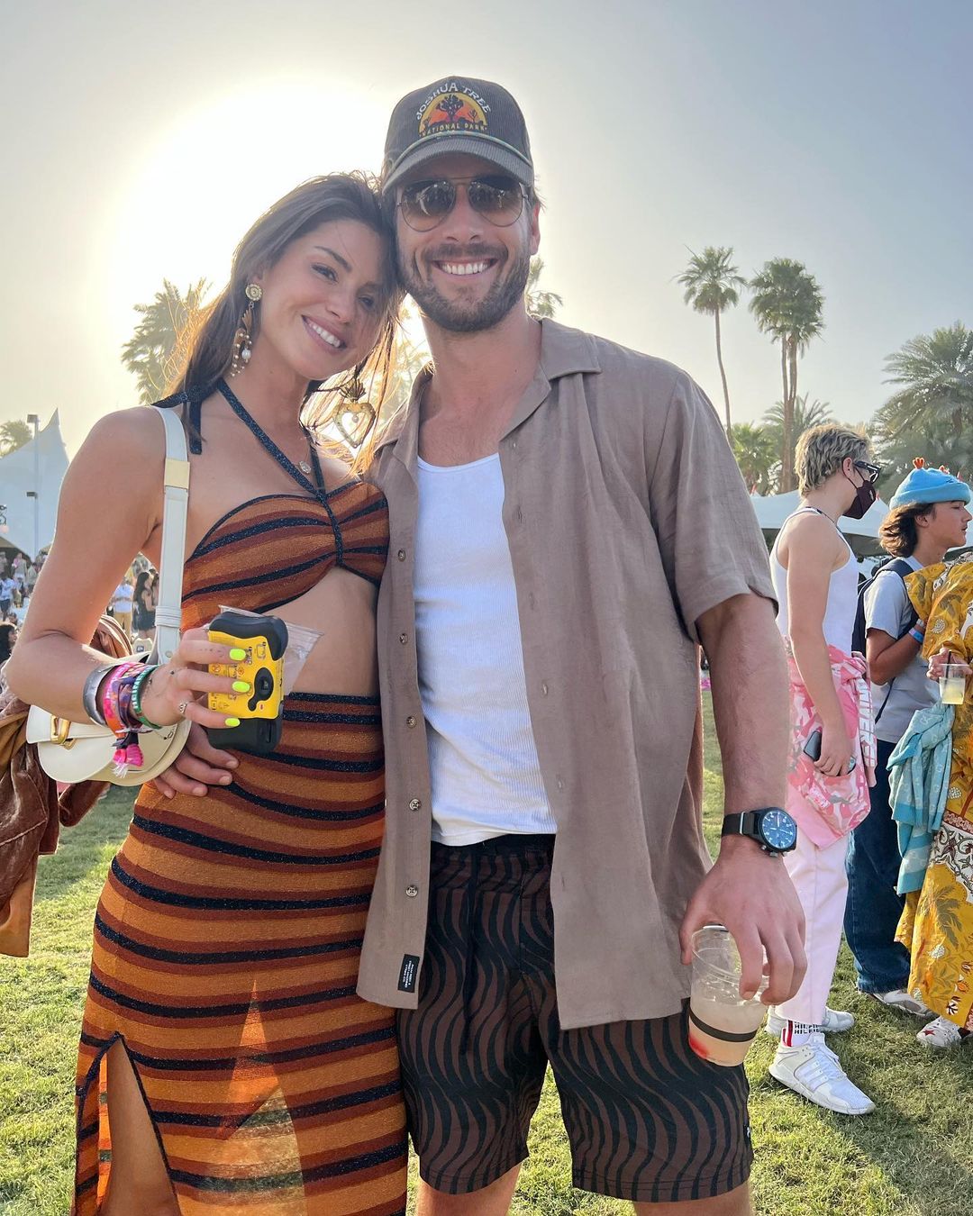 Gigi Paris and Glen Powell posing for a picture outdoors.