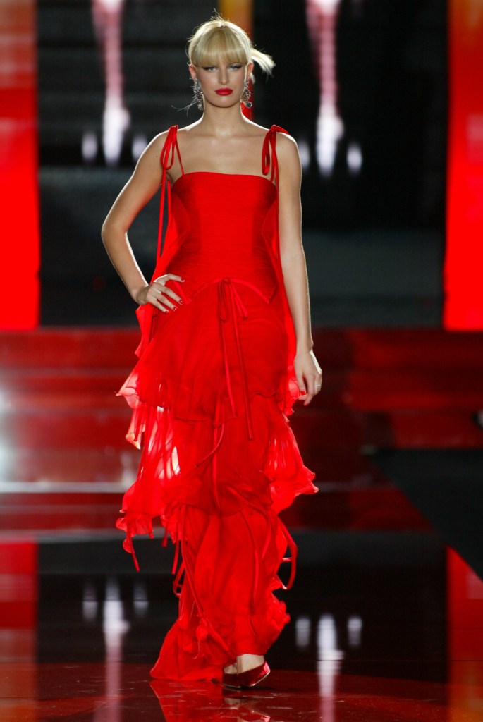 A model showcasing the red layered gown on the Valentino fall 2003 runway.