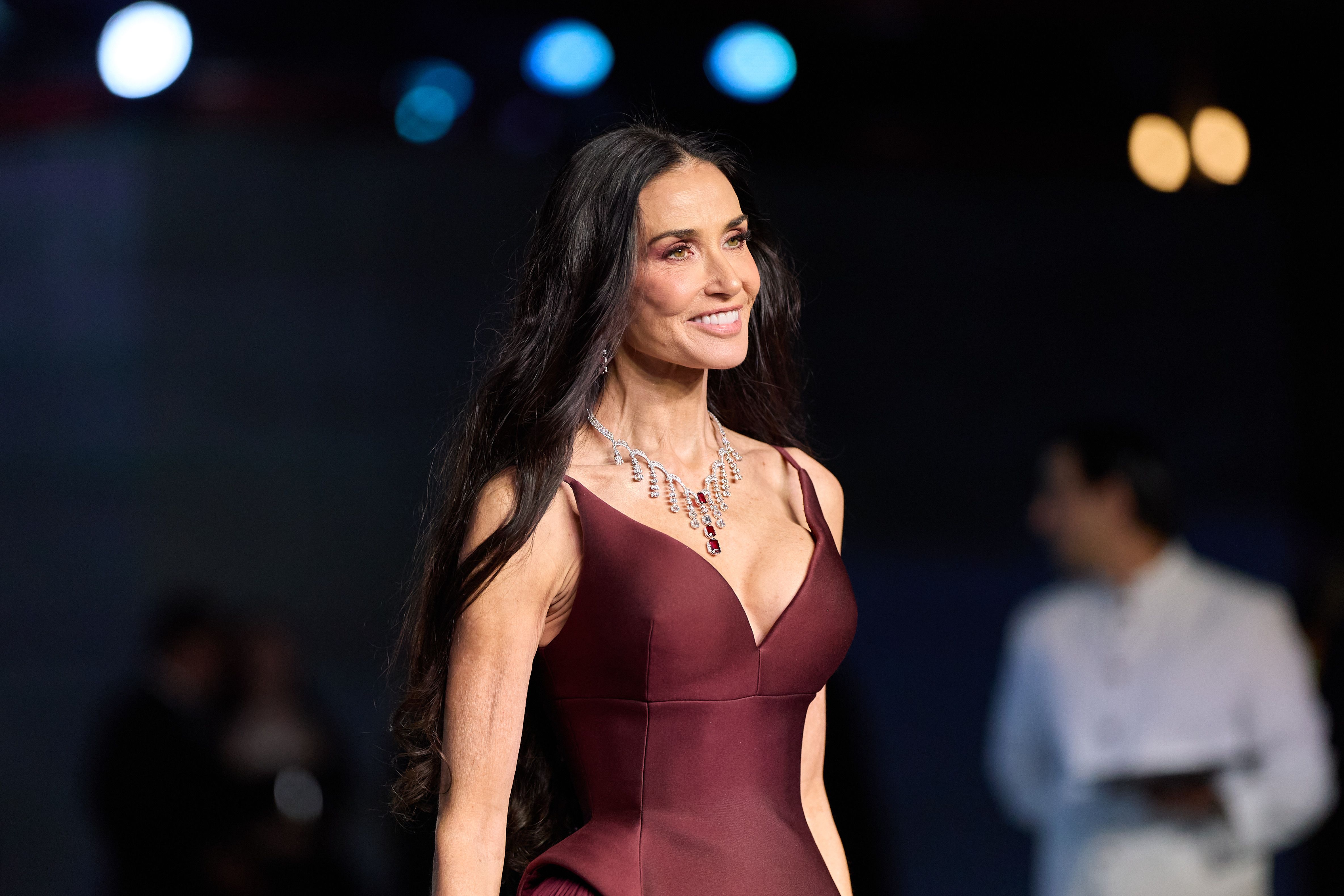 Demi Moore in a burgundy Prada gown and diamond and ruby necklace.